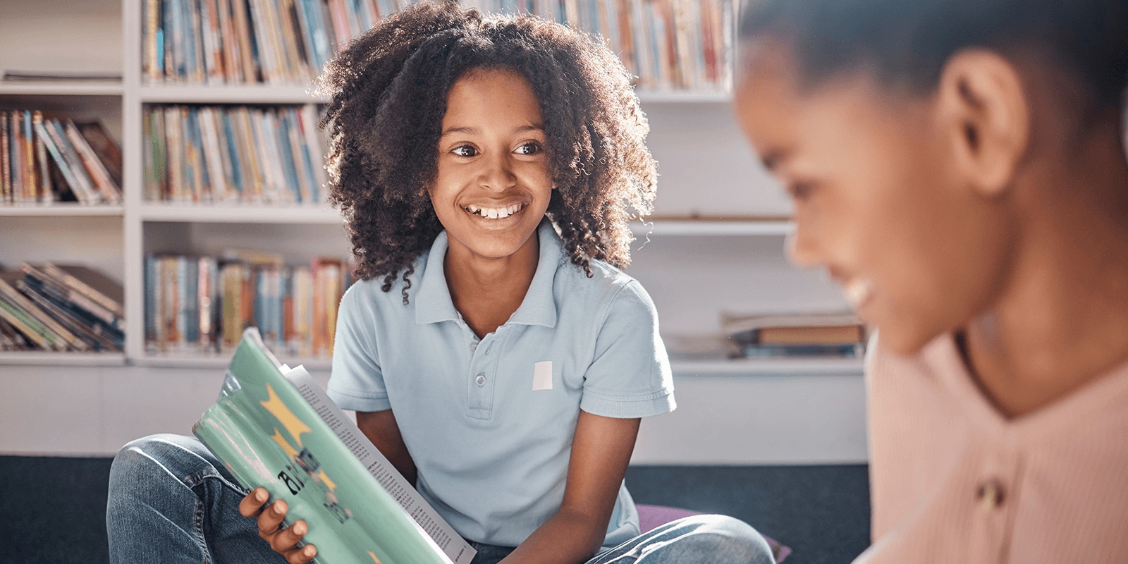 Students reading book in library
