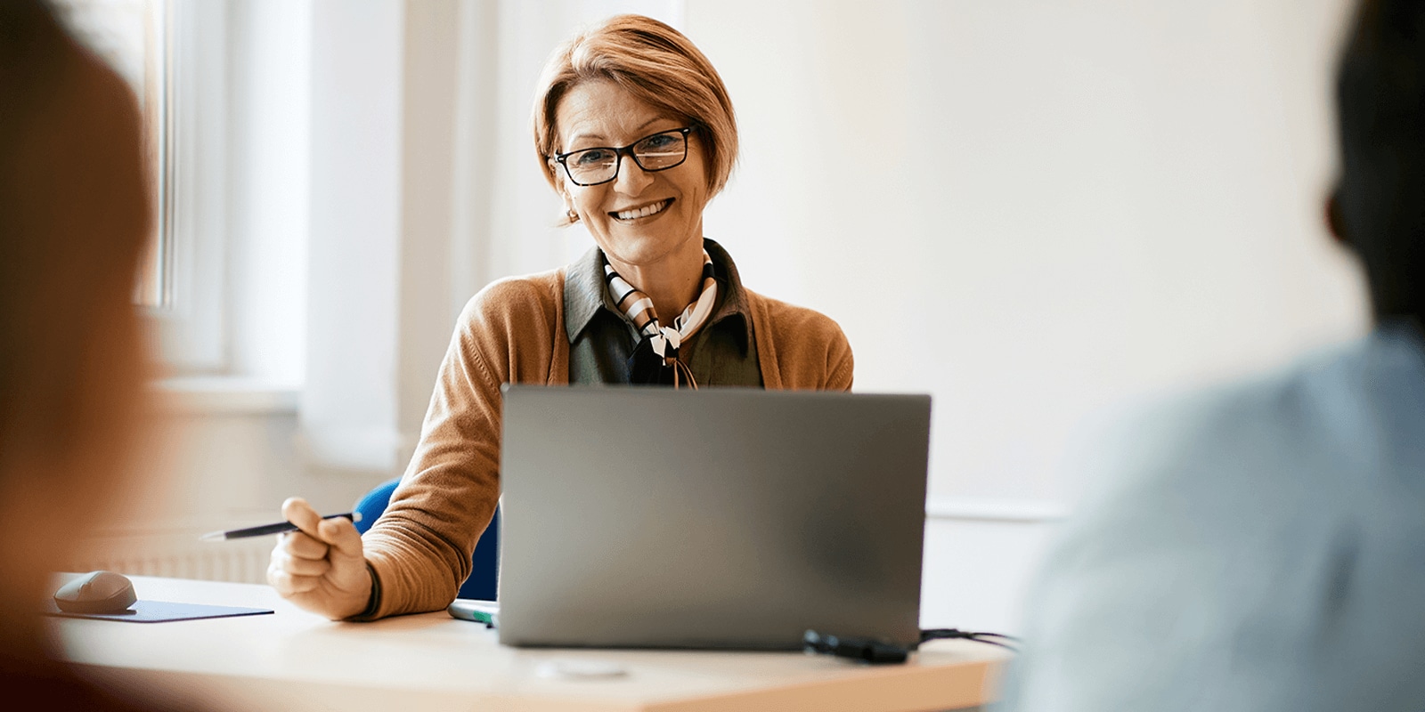 Smiling professional looking up from her laptop computer