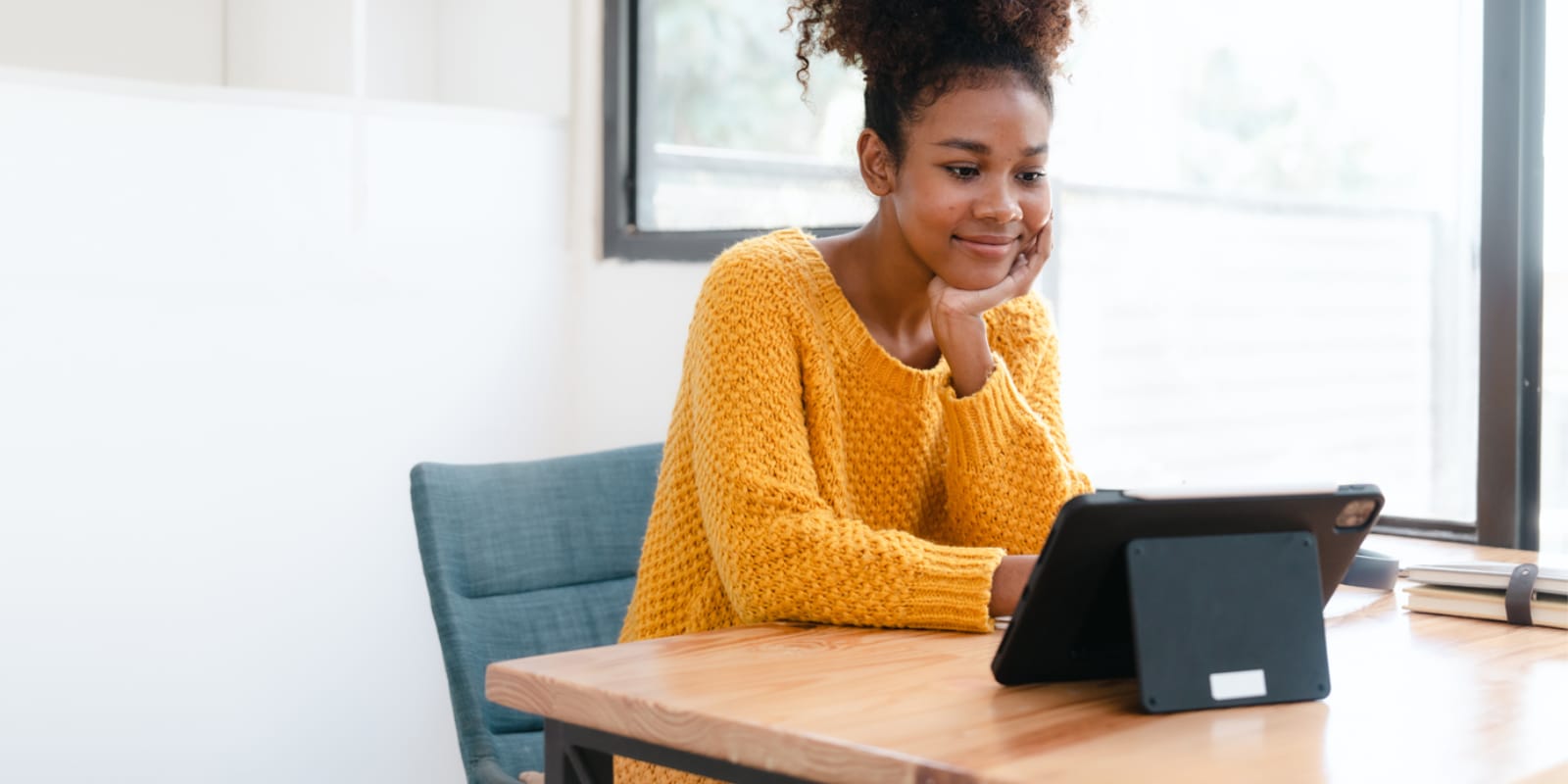 Adult male smiling while looking at a tablet computer