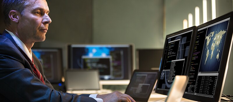 Government worker sitting at a desktop computer.